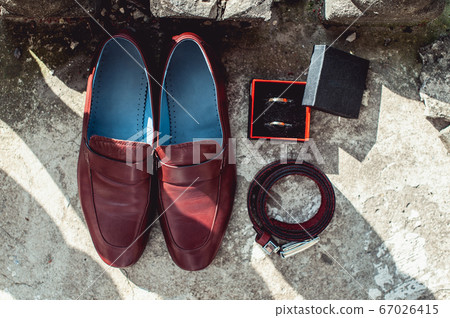 cherry men's shoes, belt and wedding rings in a box. groom's accessories at the wedding day 67026415