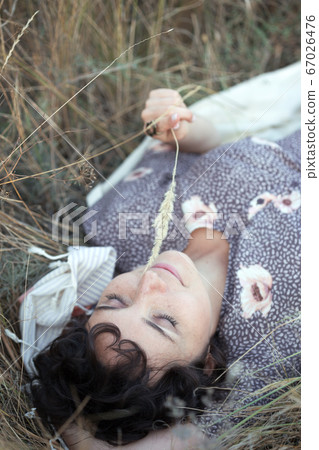 girl lies in dry grass 67026476