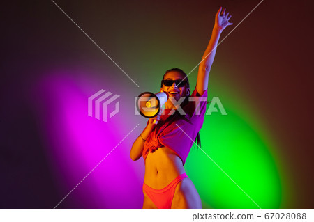 Beautiful seductive girl in fashionable swimsuit on disco bicolored neon studio background in neon light. Summer, resort, fashion and weekend concept Beautiful seductive girl in fashionable swimsuit on disco bicolored neon studio background in neon light. Summer, resort, fashion and weekend concept 67028088