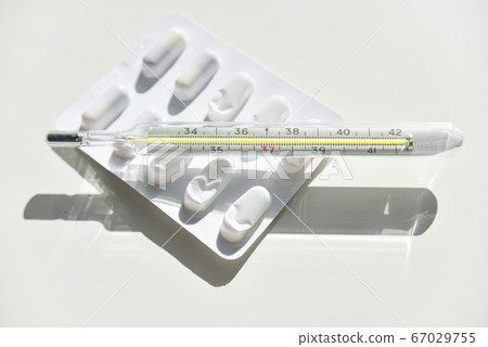 isolated thermometer and pills on the white isolated thermometer and pills on the white 67029755