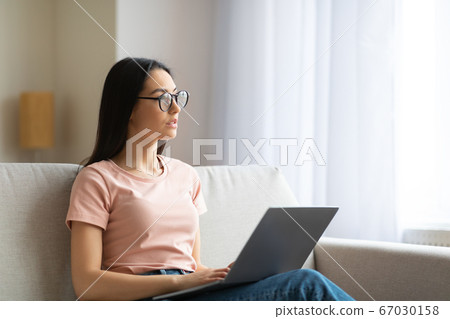 Woman Working On Laptop Thinking Sitting On Couch At Home Woman Working On Laptop Thinking Sitting On Couch At Home 67030158