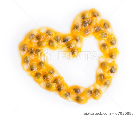 passion fruits seeds in the shape of a heart isolated on white background. maracuya with clipping path. Top view. Flat lay passion fruits seeds in the shape of a heart isolated on white background. maracuya with clipping path. Top view. Flat lay 67030893