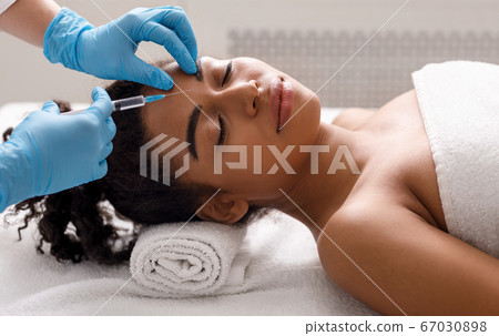 Black woman getting beauty injection at spa Black woman getting beauty injection at spa 67030898