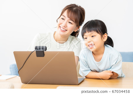 Parents and children enjoying an online seminar on a laptop Parents and children enjoying an online seminar on a laptop 67034458