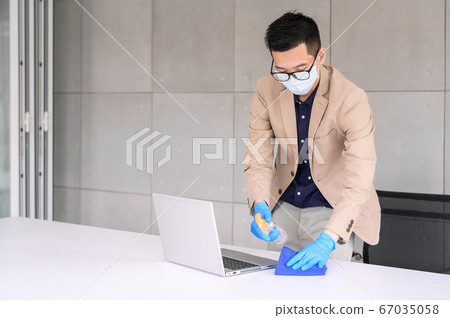 Businessman using microfiber cloth and alcohol Businessman using microfiber cloth and alcohol 67035058