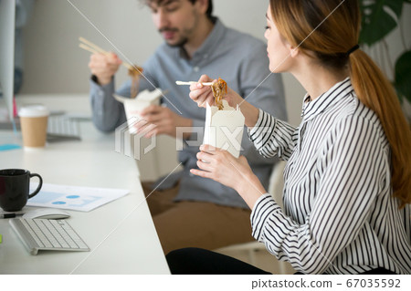 Office people eating chinese food in noodle box during lunch 67035592