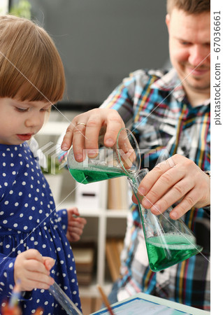 Man and little girl play with colourful liquids Man and little girl play with colourful liquids 67036661