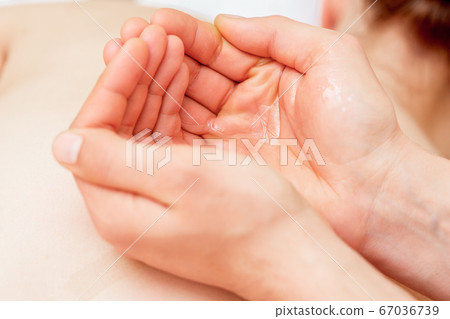 Massage oil in palms of massager. 67036739