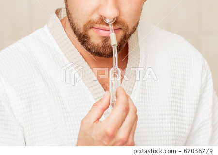 Man receives nasal inhalation. Man receives nasal inhalation. 67036779