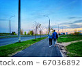 A young couple walks down the street in the evening. The view from behind. mobile photo. 67036892