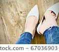 A pair of feet wearing blue and white shoes 67036903
