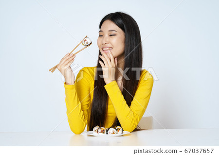 Woman in yellow sweater diet sushi rolls tradition 67037657