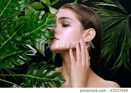 Beautiful woman green leaves island nature tropics 67037689