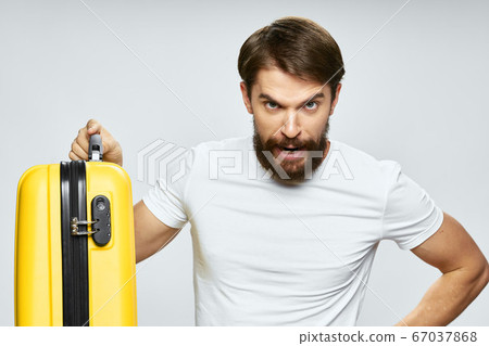 Handsome man with a yellow suitcase and a surprised look of travel  67037868