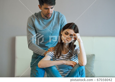 A young couple in a bedroom 67038042