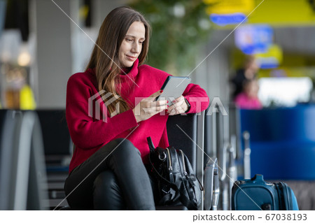 Young woman reading book waiting for flight Young woman reading book waiting for flight 67038193