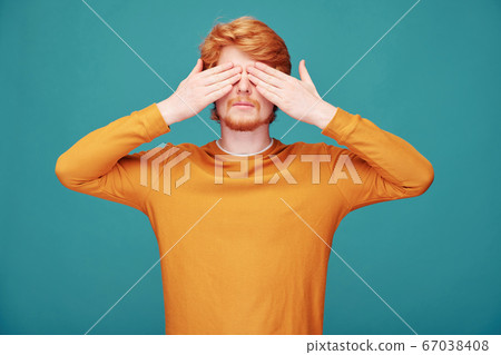 Redhead man closing eyes with hands Redhead man closing eyes with hands 67038408