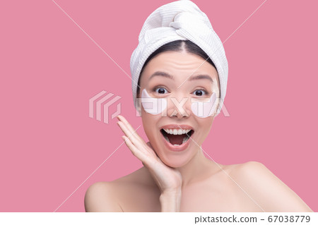 Woman using eye-patches during everyday skincare procedure Woman using eye-patches during everyday skincare procedure 67038779