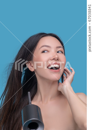 Happy woman drying her long dark hair Happy woman drying her long dark hair 67038841