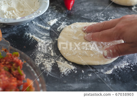 Womans hands, flour and dough. A woman is 67038903