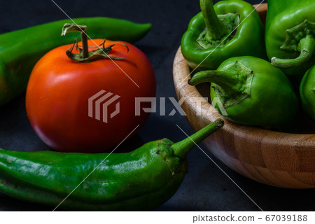 tomato and chili pepper on a dark background tomato and chili pepper on a dark background 67039188