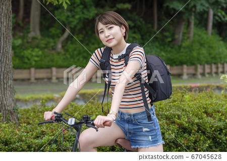 Woman with bicycle in the park 67045628