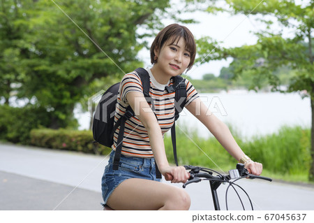 Woman with bicycle in the park 67045637