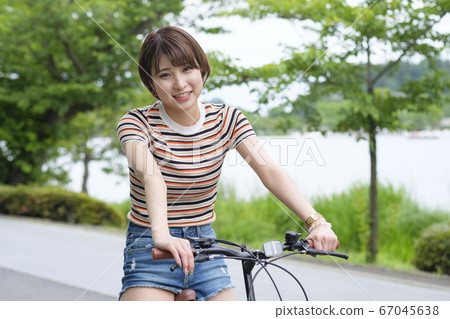 Woman with bicycle in the park 67045638