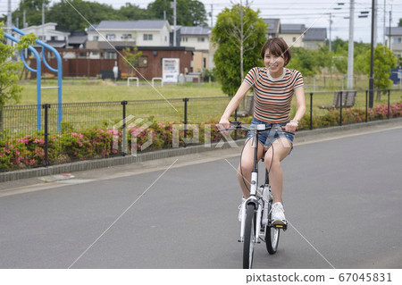女人在住宅區騎自行車 67045831