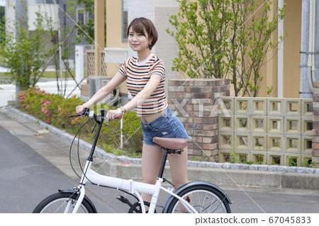 Woman riding a bicycle in a residential area 67045833