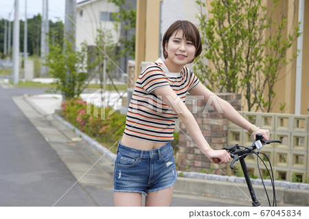 Woman riding a bicycle in a residential area 67045834