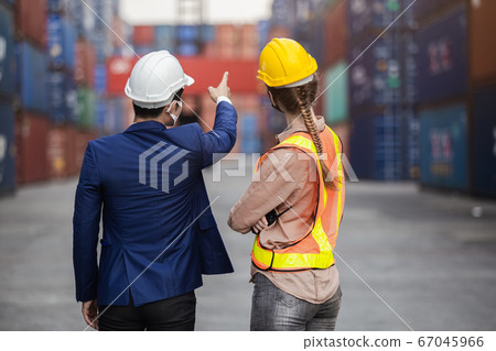 Teamwork foreman man and woman checking containers in cargo ship, Industrial container cargo. Teamwork foreman man and woman checking containers in cargo ship, Industrial container cargo. 67045966
