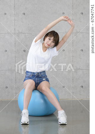 Woman playing with a balance ball Woman playing with a balance ball 67047741