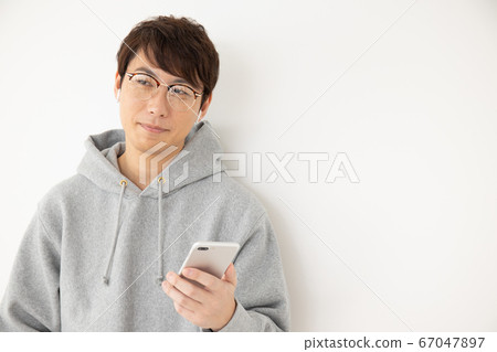 Man wearing earphones and listening to music 67047897