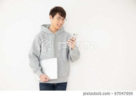 Man listening to audio with earphones 67047899