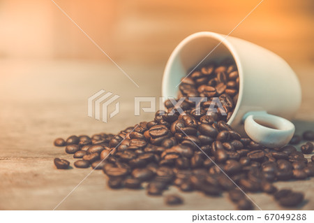 The coffee beans in the cups on the old wooden 67049288