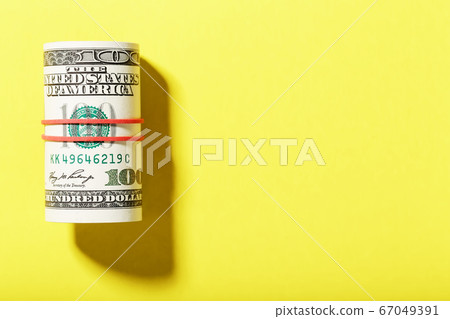 A roll of hundred-dollar American bills is tied 67049391