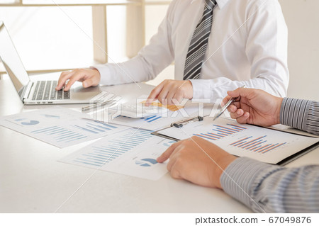 Two business leaders discussing the charts and graphs showing the results, Planning to start a new strategy for big success Two business leaders discussing the charts and graphs showing the results, Planning to start a new strategy for big success 67049876