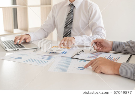 Two business leaders discussing the charts and graphs showing the results, Planning to start a new strategy for big success Two business leaders discussing the charts and graphs showing the results, Planning to start a new strategy for big success 67049877