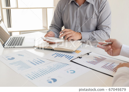 Two business leaders discussing the charts and graphs showing the results, Planning to start a new strategy for big success Two business leaders discussing the charts and graphs showing the results, Planning to start a new strategy for big success 67049879