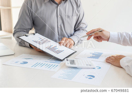 Two business leaders discussing the charts and graphs showing the results, Planning to start a new strategy for big success Two business leaders discussing the charts and graphs showing the results, Planning to start a new strategy for big success 67049881