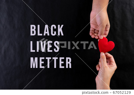 Woman hand giving red heart to child. Black lives matter concept. Woman hand giving red heart to child. Black lives matter concept. 67052129