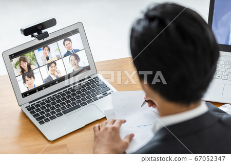 Businessman attending an online meeting 67052347