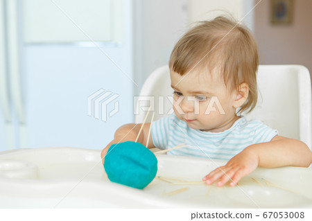 girl sculpts from plasticine. a child makes a hedgehog craft. development of fine motor skills with toothpicks 67053008