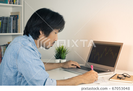 Asian Forex Trader or Investor Writing Financial Report and Trading Forex or Stock in Vintage Tone 67053048