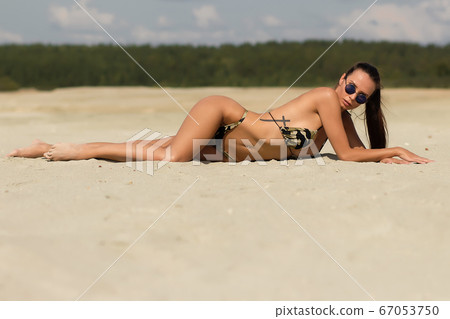 Seductive female resting on beach 67053750