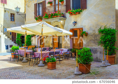 Street cafe with tables and chairs in Tuscany, Pienza, Italy 67056046