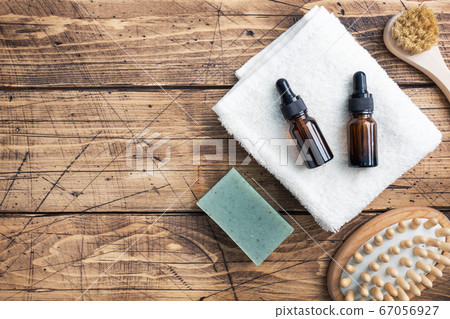 Concept SPA and Wellness. Massage brush, cosmetic oils and soap. Wooden background. Copy space 67056927