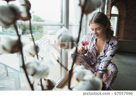 Portrait of pretty young girl in modern apartment in the morning. Resting, calm, salisfied. Youth and wellness concept. Portrait of pretty young girl in modern apartment in the morning. Resting, calm, salisfied. Youth and wellness concept. 67057096