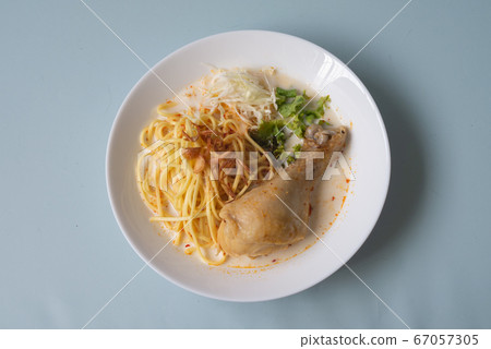 Traditional Asian spicy Laksa noodle white curry paste soup with chicken and vegetable in Singapore 67057305
